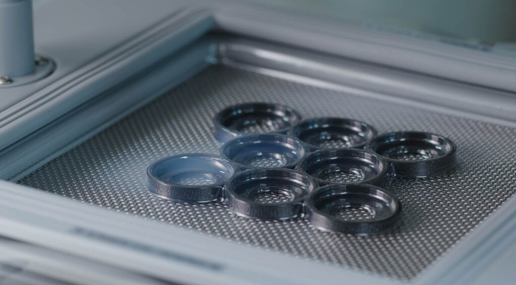 Thermoforming machine tray holding small formed plastic parts during production